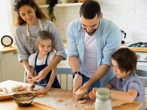 Eltern mit Kinder in der Küche am Kekse zubereiten