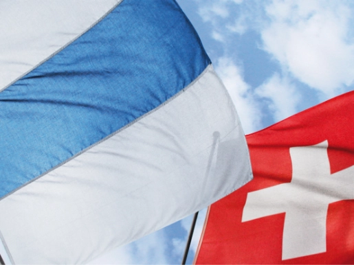 Zuger und Schweizer Fahne vor blauem Himmel