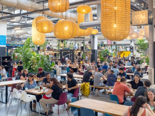 Menschen sitzen und essen in einer Foodhalle
