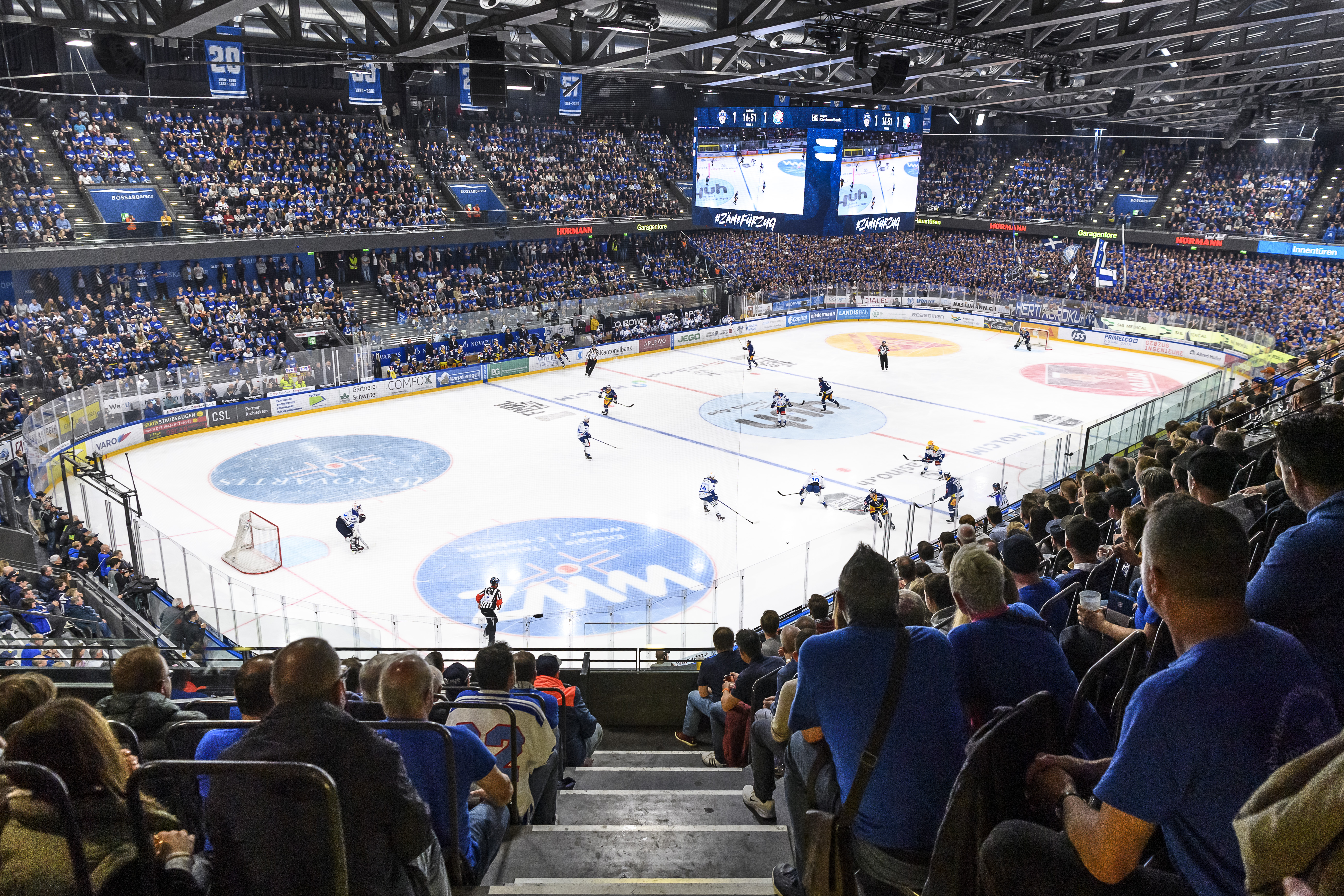 Eishockeystadion voll mit Zuschauern in Blau-Weiss